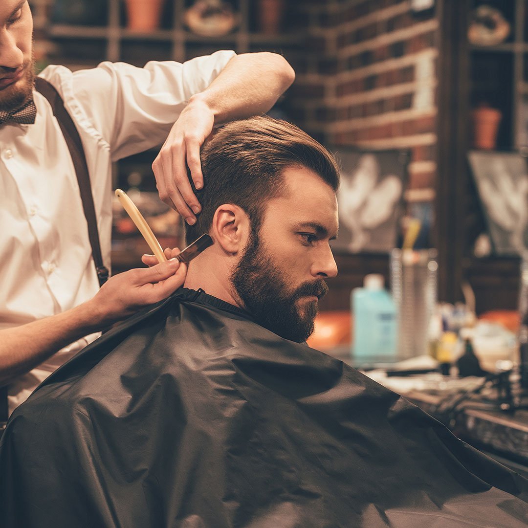Barber trimming a beard.