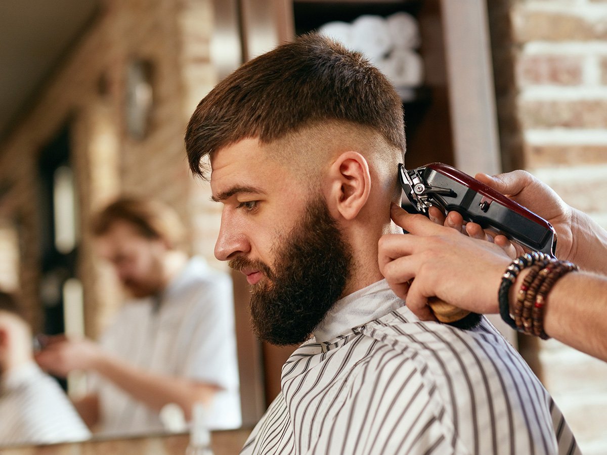 barber shaving back of man's head